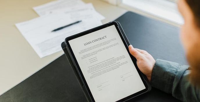 Businessman signing loan contract on tablet at office.Concept of filling documents.