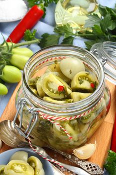 glass jar with pickled green tomatoes prepared for winter