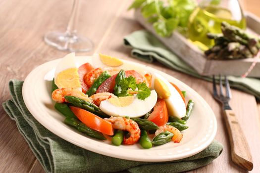 Fresh salad with asparagus, eggs, shrimp and tomatoes