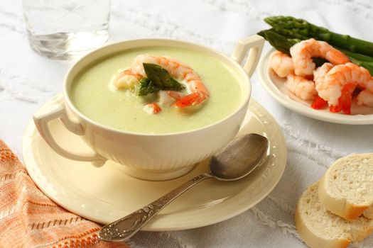 Delicious cream soup with asparagus and shrimp. Selective focus