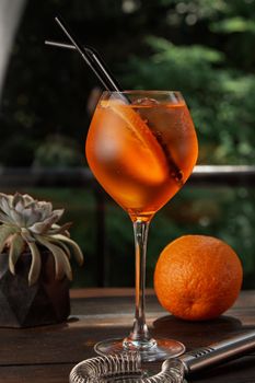 Aperol spritz on a background of green with orange. High quality photo