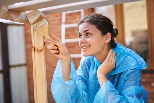 a painter with a brush in his hands paints wooden objects repairing fittings. High quality photo