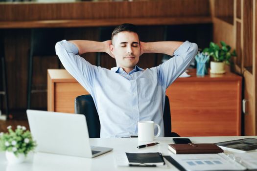 Male marketing manager resting and smiling while working to reduce drowsiness before using computers, iPads and marketing materials