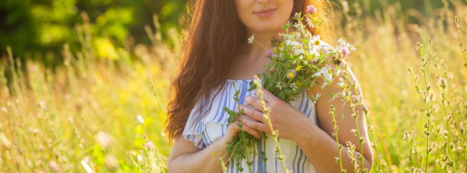 Young woman picking flowers in the meadow in summer