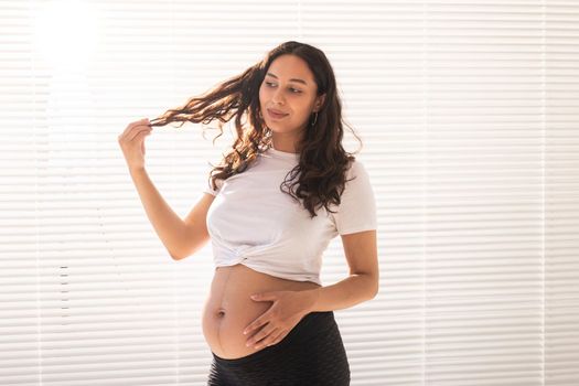 Pregnant woman touching her belly, copy space. Pregnancy and maternity leave.