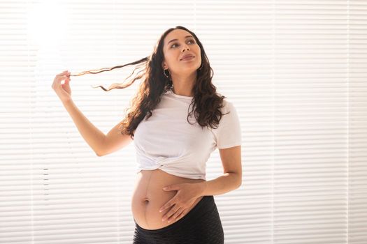 Pregnant woman touching her belly, copy space. Pregnancy and maternity leave.