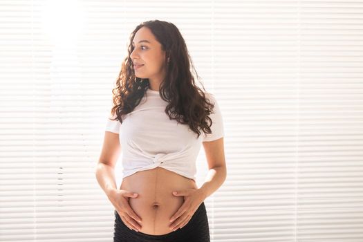 Pregnant woman touching her belly, copy space. Pregnancy and maternity leave.