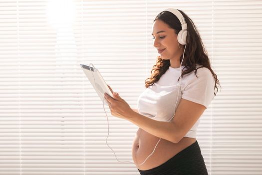 Pregnant woman listening music in headphones
