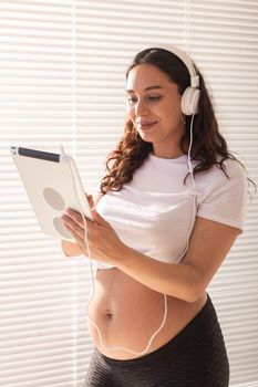 Pregnant woman listening music in headphones
