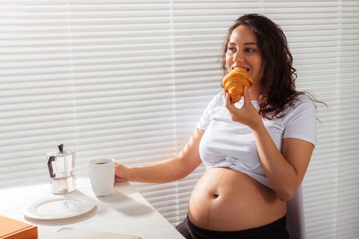 Pregnant woman eating breakfast. Pregnancy and maternity leave.