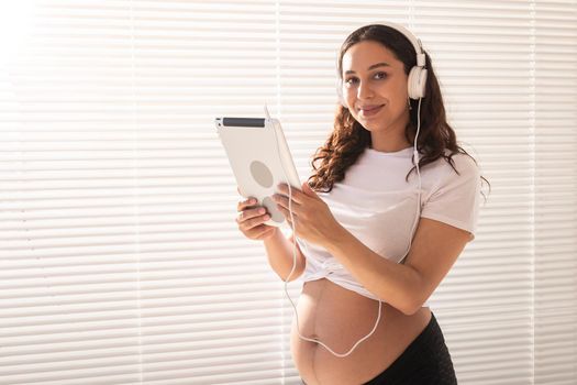 Pregnant woman listening music in headphones