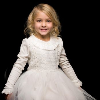 Beautiful little girl on a black background. Studio photography