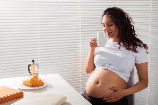 Pregnant woman eating breakfast. Pregnancy and maternity leave.