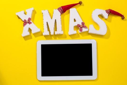 Smartphone with Christmas decorations. Christmas mock up template. View from above. yellow background