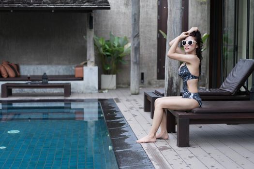 young woman relaxing on a chair at swimming pool