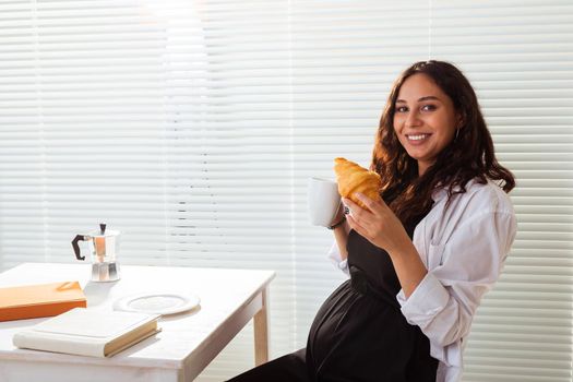 Pregnant woman eating breakfast. Pregnancy and maternity leave.
