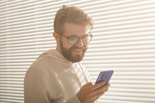 Happy man using mobile phone at home or at office.