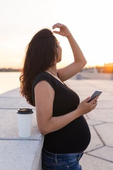 Pregnant woman feeling lovely and relax on embankment with warm light in morning