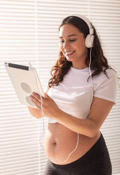 Pregnant woman listening music in headphones