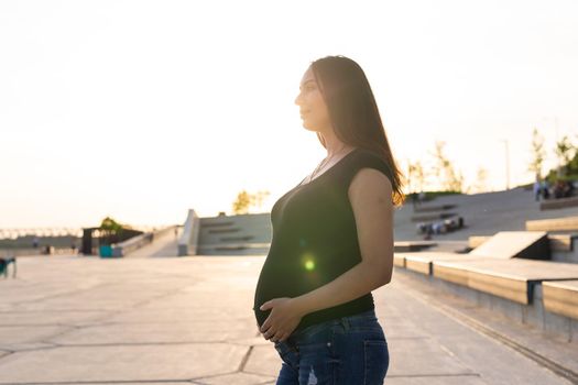 young happy pregnant woman relaxing and enjoying life in nature