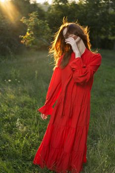 woman in red dress posing nature sun fun. High quality photo