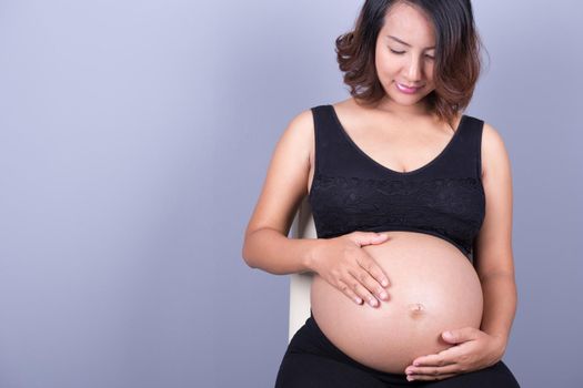 Beautiful pregnant woman on gray background