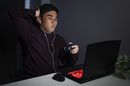 Stressed depressed young man using joystick to playing games