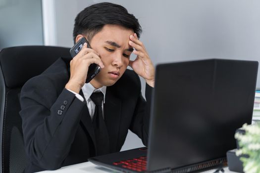 depressed man in suit is talking on smartphone