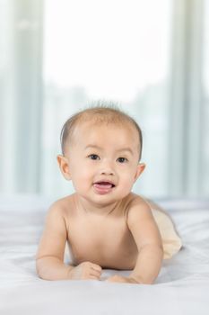 portrait of baby on a bed in bedroom at home