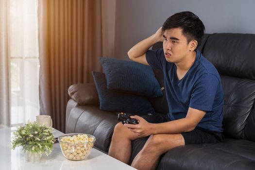 sad young man playing video games and loses