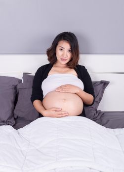 pregnant woman lying on bed in the bedroom at home