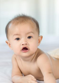 portrait of baby on a bed in bedroom at home