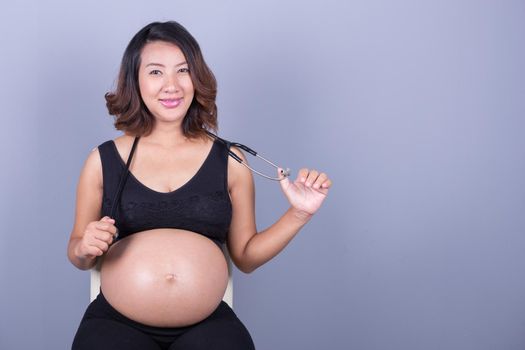 happy pregnant asian woman with stethoscope 