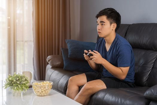 young man playing video game with joystick in the living room