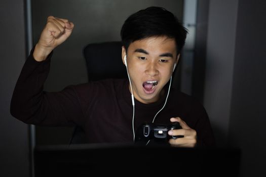 happy young man using joystick to playing games