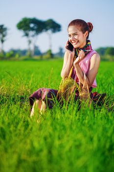 farmer woman calling on the mobile phone in a rice field, Thailand