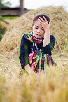 worried woman resting with the straw in field, Thailand