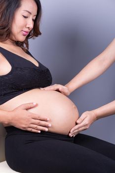 hand of doctor touching belly of pregnant woman 