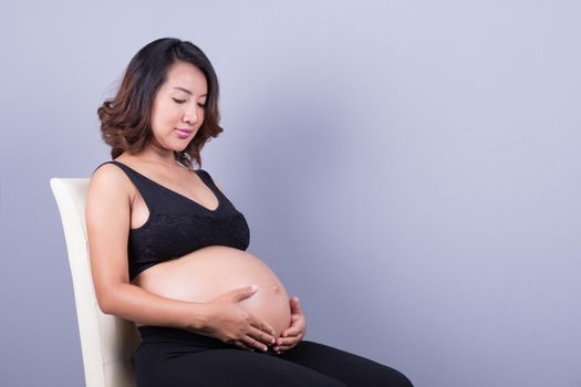 Beautiful pregnant woman on gray background