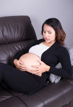 Pregnant woman getting a contraction in the living room at house