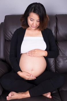 portrait of pregnant woman resting at home on sofa