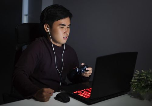 Stressed depressed young man using joystick to playing games