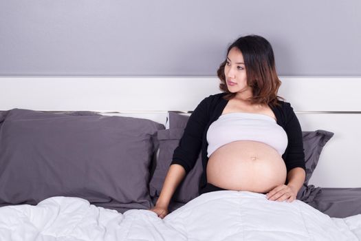 pregnant woman lying on bed in the bedroom at home