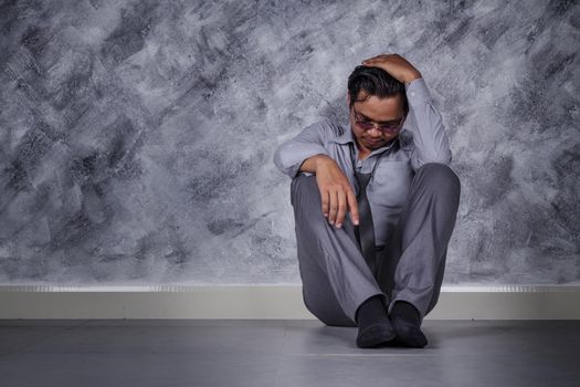 young depressed businessman sitting on the floor