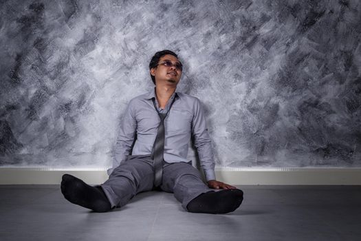 young depressed businessman sitting on the floor