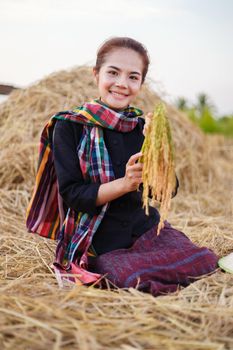 farmer woman holding a rice with the straw in field, Thailand
