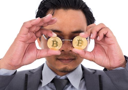 man holds a coin bitcoin in front of his eyes isolated on white background