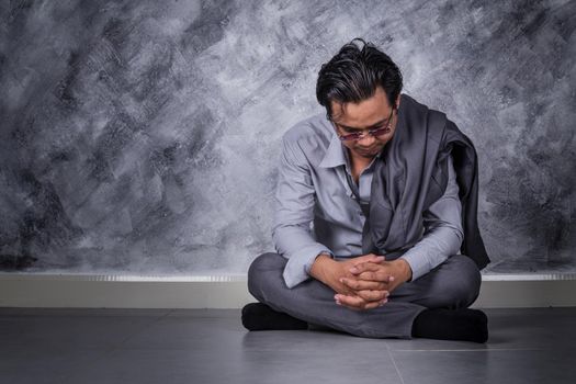 young depressed businessman sitting on the floor