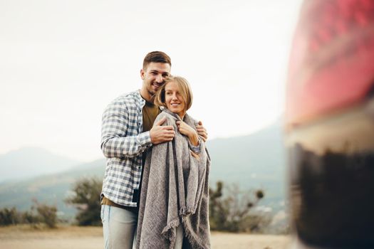 Happy loving couple hiking and hugging in mountains, close up