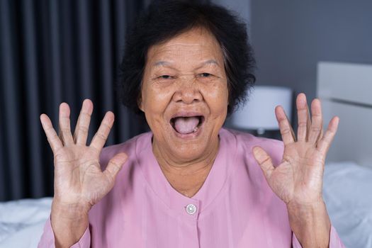 senior woman with surprised expression in bedroom